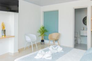 卡普兰干HOTEL PIEDRA VIVA的卧室配有白色家具和白色椅子