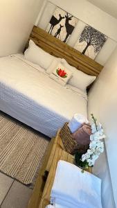VillalbaPARAISOS DE GABRIELA的一间卧室,配有一张床和一篮鲜花