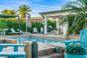 迈阿密花园Oasis with Pool Spa Games 5BR L21的后院的游泳池,带椅子和房子