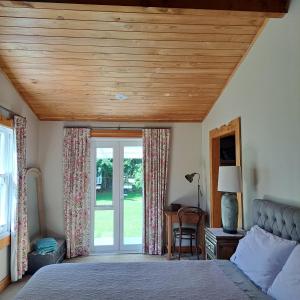陶波The Homestead的一间卧室设有一张木天花板床。