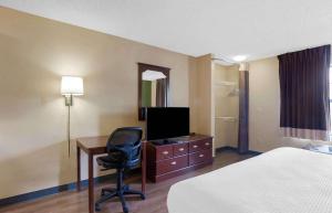 Ridgeland罗彻斯特-亨里埃塔-长住酒店的酒店客房配有一张床和一张书桌及一台电视