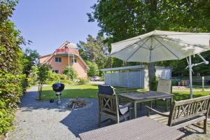 格洛韦FeWo am Wald FeWo 03 - Balkon, Gartennutzung, Sauna的一张带雨伞和烧烤架的野餐桌