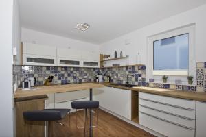 布雷格Ferienhaus Luna Haus - Terrasse, Garten, Sauna的厨房配有白色橱柜和蓝色及白色瓷砖