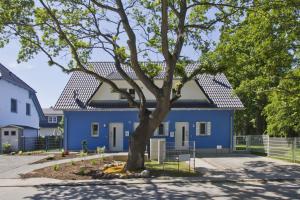 布雷格Ferienhaus Luna Haus - Terrasse, Garten, Sauna的前面有一棵树的蓝色房子