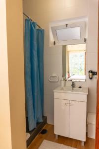 圣维森特Madeira Surf Lodge的浴室设有水槽和蓝色的浴帘