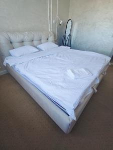 基希讷乌Guest House Гостевой Дом的一张配有白色床单和枕头的大床