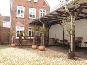 胡苏姆Lodge am Oxenweg - Zimmer 2的种植了盆栽植物的庭院和砖砌建筑