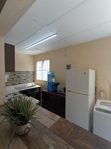 夸察夸尔科斯Excelente casa para descansar的厨房配有白色冰箱和水槽