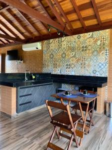 卡皮托利乌Chalés Estância Campestre的厨房配有桌椅和瓷砖墙。
