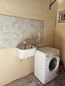 福尔摩沙Pringles Dpto Temporario 2的客房内的洗衣机和水槽