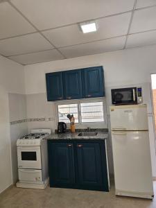 福尔摩沙Pringles Dpto Temporario 2的厨房配有蓝色橱柜和白色冰箱