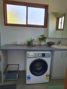 切尔滕纳姆Beach Garden Getaway的厨房配有位于柜台下的洗衣机