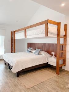 帕拉卡斯Casa Z Paracas的一间卧室配有带白色床单和蓝色枕头的双层床