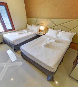 San RafaelHacienda Angelita Nature Farm and Resort的客房设有两张床和一张带窗户的桌子。