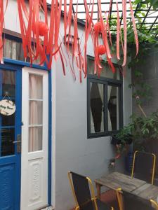芹苴Nhu's House 2的一座配有桌椅和红丝带的建筑