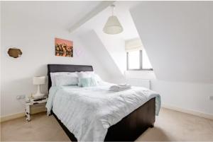KentChic DuoRooms with Modern Comfort for Families的白色卧室配有一张带白色床单的大床