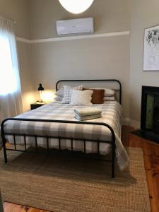 布罗肯希尔HILLSIDE HAVEN CHARMING C1920 COTTAGE Pet Friendly Sleeps 1 - 6的一间卧室配有带白色床单和枕头的床。