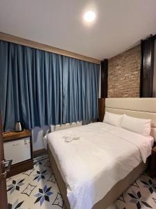伊斯坦布尔Andi Hotel的一间卧室配有一张带蓝色窗帘的大床