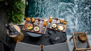 格兰岛Rhy.a Private Pool Villa的游泳池旁的餐桌上放着食物