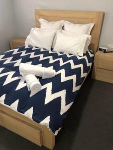 布里斯班Best Value With City View Sleeps 7的一张带蓝色和白色棉被和枕头的床