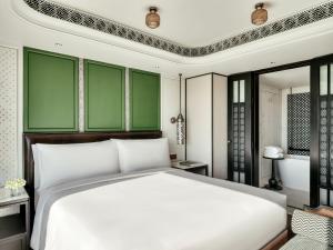 清迈InterContinental Chiang Mai The Mae Ping, an IHG Hotel的卧室设有白色的床和绿色的墙壁