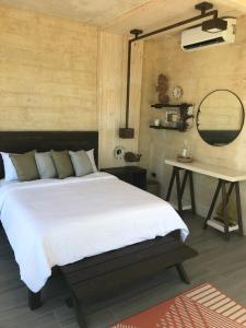 卡莫特斯群岛The LivingSpace Villa的一间卧室配有一张床、一张桌子和一面镜子