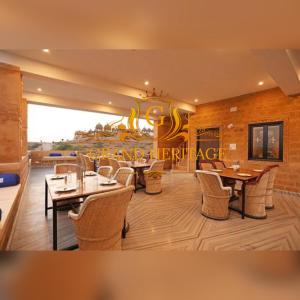 斋沙默尔Hotel Grand Heritage Jaisalmer的一间在房间内配有桌椅的餐厅