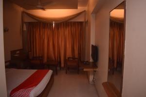 塞恩HOTEL DHIRAJ的一间卧室配有一张床、一张书桌和一个窗户。