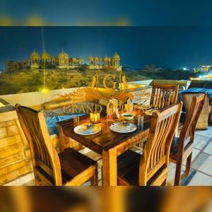 斋沙默尔Hotel Grand Heritage Jaisalmer的一张木桌和椅子,享有城市美景