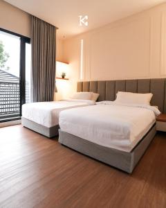 万隆BUMINAKURA的一间卧室设有两张床和大窗户
