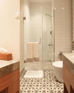 万隆BUMINAKURA的一间带玻璃淋浴和卫生间的浴室