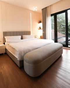 万隆BUMINAKURA的一间卧室设有一张大床和一个大窗户