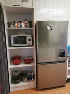 BrakpanGarden View Home的冰箱,配有微波炉和一些锅碗瓢盆