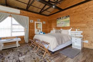 比勒陀利亚Abendruhe Lodge的一间卧室配有一张大床和一张书桌