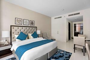 迪拜Aliving Elite Studio Celestia A Dubai South的一间卧室配有一张带蓝色枕头的大床