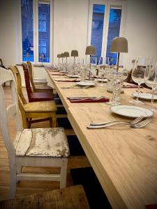 马尔什昂法梅讷Li Ter Hôtel的长木桌子,带椅子和盘子,玻璃杯