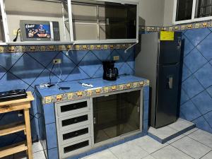 科马亚瓜Casco histórico Atenea的厨房配有蓝色的柜台和冰箱。