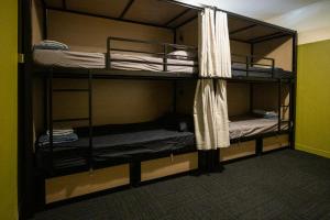 阿德莱德Base Camp Hostel的一间房间,设有三张双层床