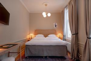 斯德哥尔摩Clas på Hörnet的一间卧室配有一张带白色床单的床和一扇窗户。