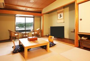 白滨白浜・温泉リゾート海岳的客厅配有桌子和电视