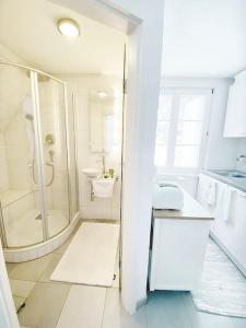 福尔巴赫Apartment Rose的带淋浴和盥洗盆的白色浴室