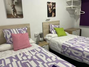 波多黎多德萨贡托艾尔巴赫芬酒店的紫绿色客房内的两张床