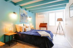 圣特罗让莱班chez Frederique的一间卧室配有一张蓝色天花板的床