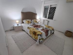 突尼斯Appartement Cozy aux Berges du Lac 1的一间卧室配有一张床、两盏灯和一个窗户。