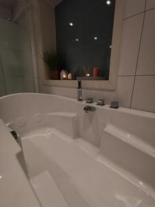 安德内斯Andenes Sentrum Apartment的浴室设有白色浴缸及镜子