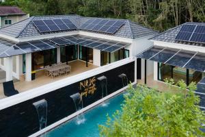 宋卡Nue Hatyai Pool Villa 147的享有房子的空中景色,上面设有太阳能电池板