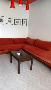 曾蒙海滩Samui Mekkala Resort的客厅里一张红色的沙发,配有茶几