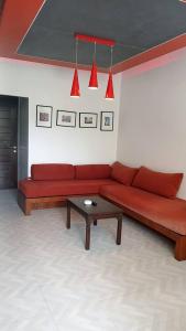 曾蒙海滩Samui Mekkala Resort的客厅配有红色的沙发和桌子