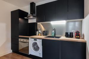 里尔Lille Grand Place - 1 bedroom apartment的厨房配有黑色橱柜和洗衣机。