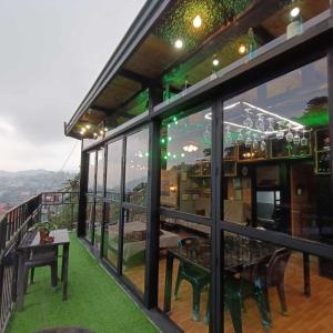 碧瑶Holyghost Veranda Baguio Transient Guest House 42 step rooftop的客房设有窗户和阳台桌子。